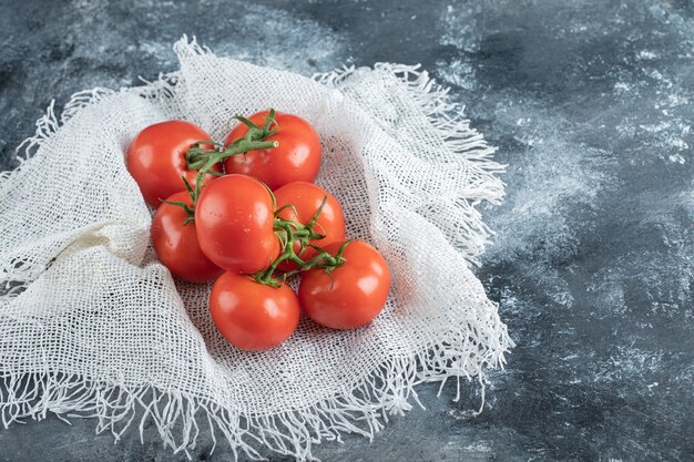 Foto gratuita algunos de jugosos tomates en cilicio blanco.