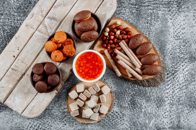 Algunos pasteles pequeños con gofres y gelatina en platos y cuencos con textura ligera