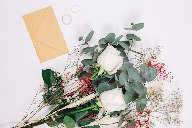 Foto gratuita alianzas de boda con ramo de flores