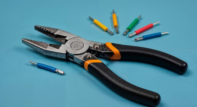 Alicates y conectores de cable sobre superficie azul