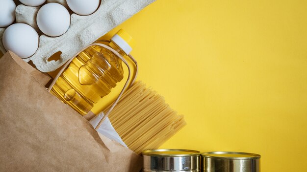 Alimentos en una caja de cartón sobre un fondo amarillo