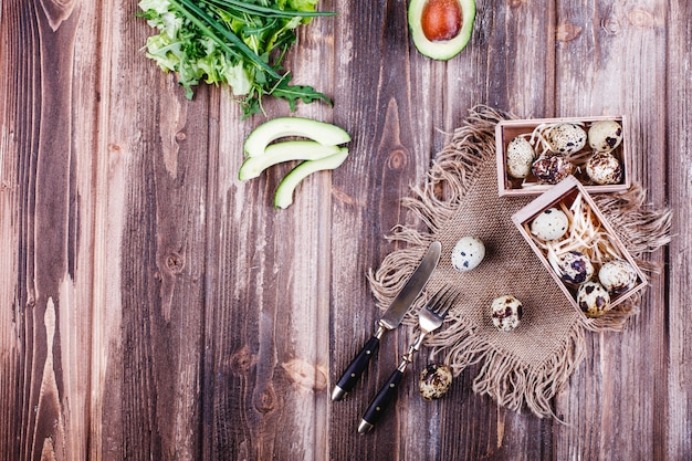 Alimentos frescos y saludables, proteínas. Huevos de codorniz en caja de madera de pie sobre la mesa rústica
