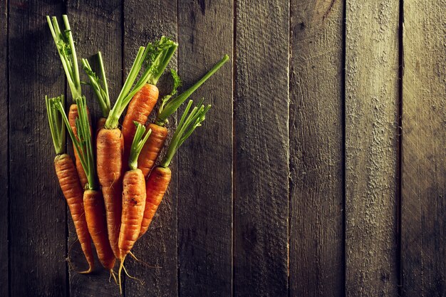 Alimentos Orgánicos Fondo De Vegetales Coloridos. Zanahorias frescas sabrosas en la tabla de madera. Vista superior con espacio de copia. Concepto De Vida Saludable.