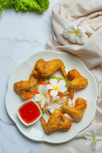 Alitas fritas con salsa de pescado, bellamente decoradas y servidas.