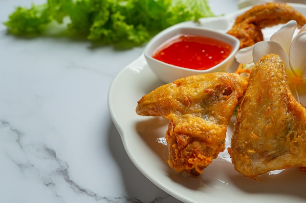 Alitas fritas con salsa de pescado, bellamente decoradas y servidas.