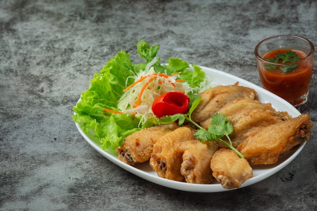 Alitas fritas con salsa de pescado, hierbas bellamente decoradas y servidas.