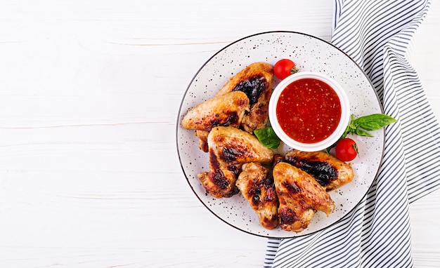 Alitas de pollo al horno al estilo asiático y salsa de tomate en un plato