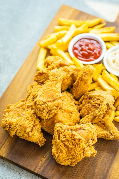 Foto gratuita alitas de pollo frito con papas fritas y tomate