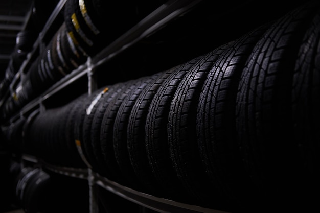 Foto gratuita almacenamiento oscuro completo o gran variedad de neumáticos nuevos en un almacén ocupado.
