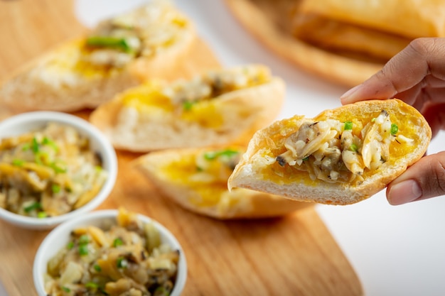 Almeja al horno con ajo y mantequilla servida con pan de ajo sobre fondo de mármol