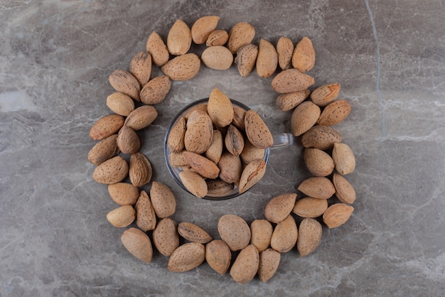 Foto gratuita almendras alrededor de un cuenco de almendras en la superficie de mármol