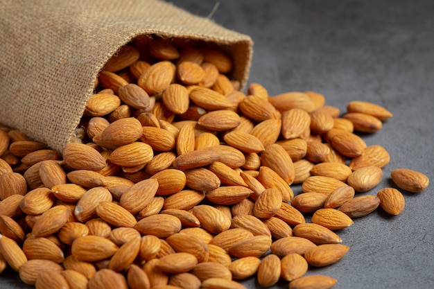 Almendras en bolsa de sackingl sobre fondo oscuro