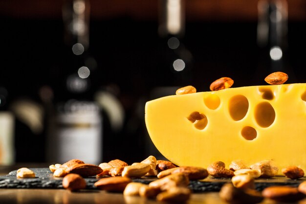 Almendras y cacahuetes se encuentran en un pedazo de queso suizo