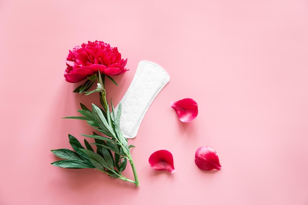 Almohadilla para mujer y flor plana concepto de salud y menstruación de la mujer