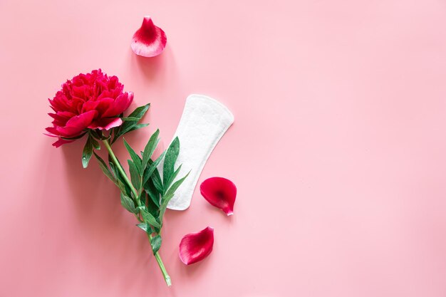 Almohadilla para mujer y flor plana concepto de salud y menstruación de la mujer