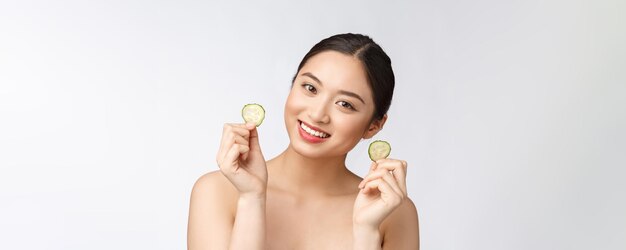 Almohadillas faciales caseras de pepino fresco casero natural máscaras faciales Mujer asiática con almohadillas de pepino y sonrisa relajarse con natural casero