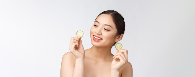 Almohadillas faciales caseras de pepino fresco casero natural máscaras faciales Mujer asiática con almohadillas de pepino y sonrisa relajarse con natural casero