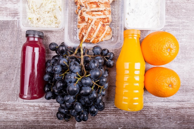 Almuerzo empacado en diferentes cajas. Una alimentación fresca y saludable sobre fondo de madera