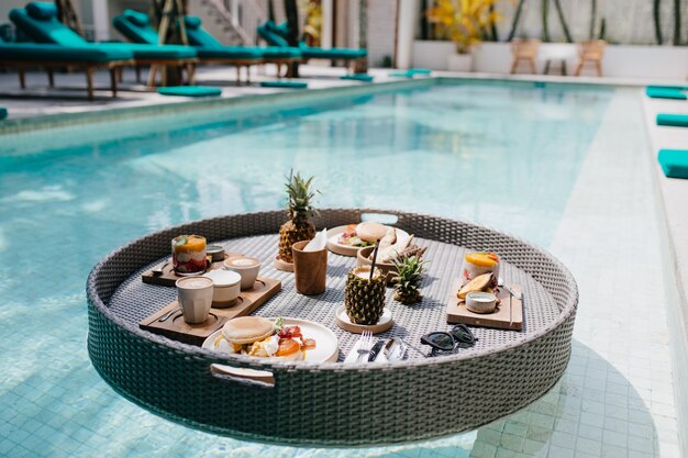 almuerzo exótico en hotel. Tiro al aire libre de mesa con frutas en la piscina.