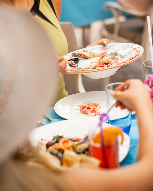 Foto gratuita alrededor de la mesa, tomando comida en un plato blanco.