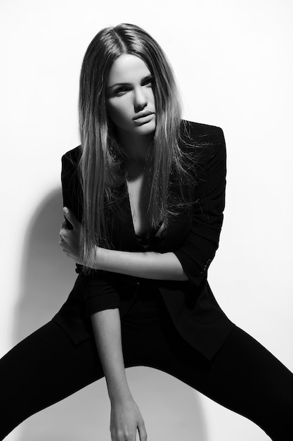 Alta moda look.glamor retrato de hermosa sexy elegante modelo caucásica joven en ropa negra posando junto a la pared