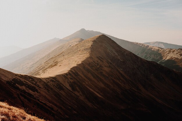 Alta montaña marrón con otras montañas