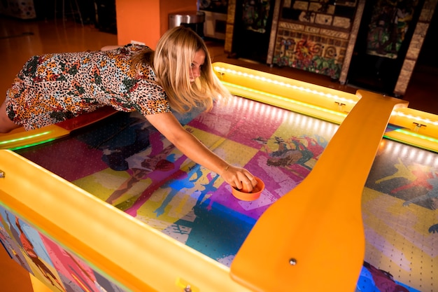 Alta vista mujer jugando air hockey