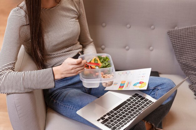 Alta vista mujer trabajando y comiendo