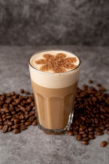 Alta vista vaso de capuchino con granos de café