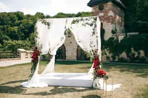 Foto gratuita altar de boda hecho de cortinas cuadradas se encuentra en el patio trasero