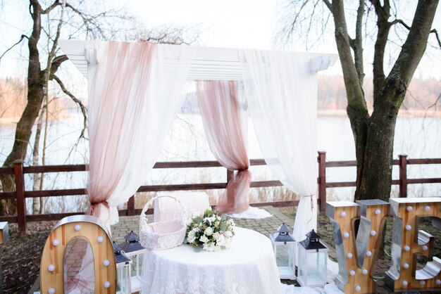 Altar de boda hermoso hecho de cortinas blancas y rosadas