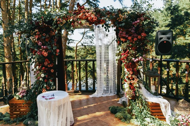 Altar de bodas hecho de spearworts coloridos y cortina blanca