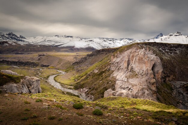 Altas montañas cubiertas de nieve bajo el cielo nublado