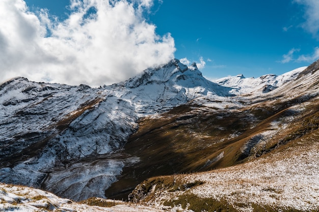 Altas montañas rocosas cubiertas de nieve bajo un cielo azul claro en Suiza