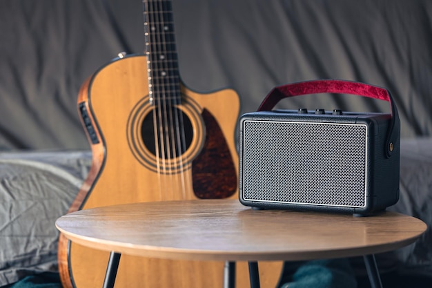 Altavoz de música y guitarra acústica en el interior de la habitación