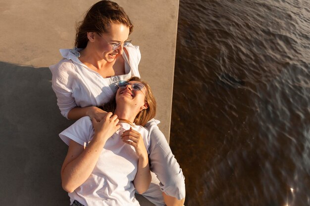 Alto ángulo de amigas sonrientes divirtiéndose junto al lago con espacio de copia