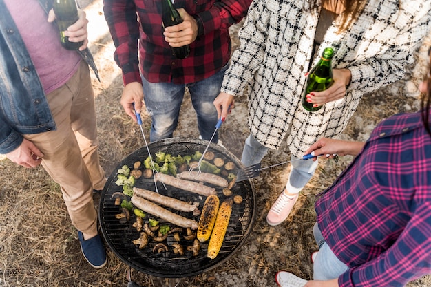 Foto gratuita alto ángulo de amigos con una barbacoa con cervezas