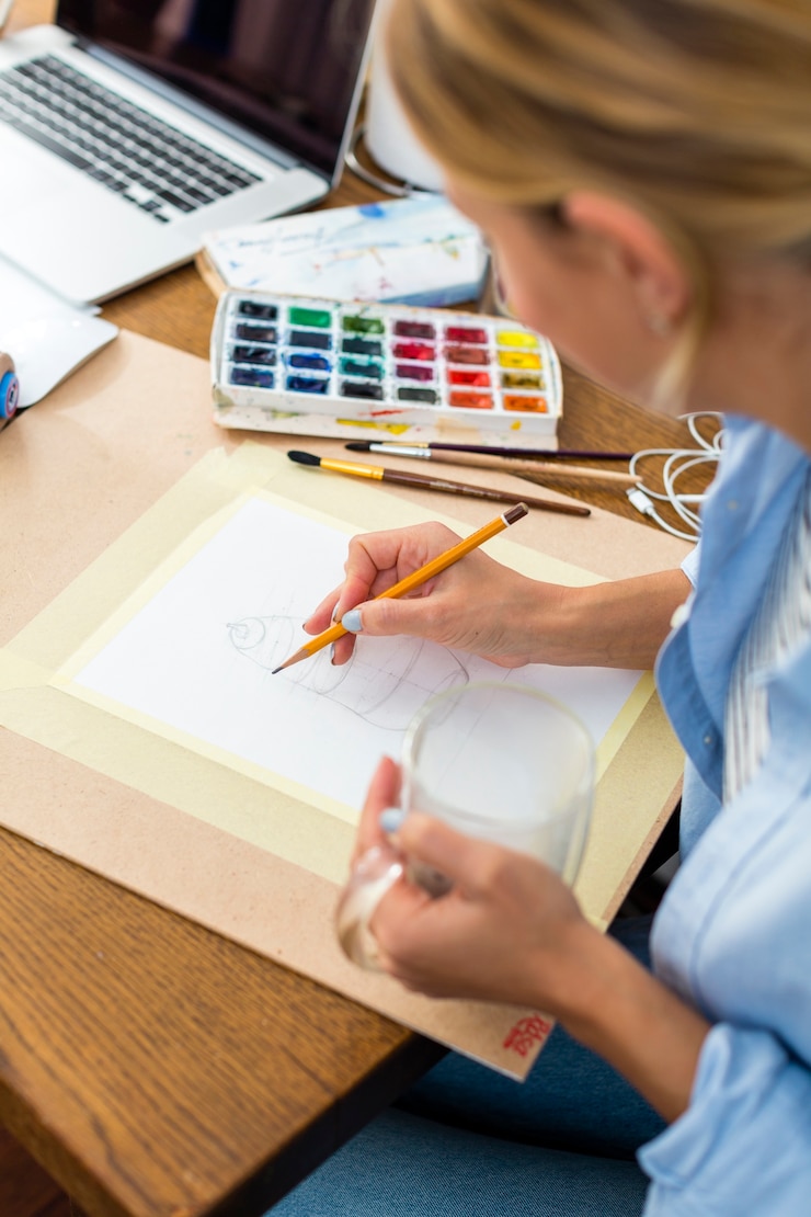 Foto gratuito alto ángulo del artista dibujando sobre papel