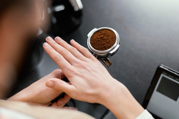 Alto ángulo de barista masculino preparando la taza de café