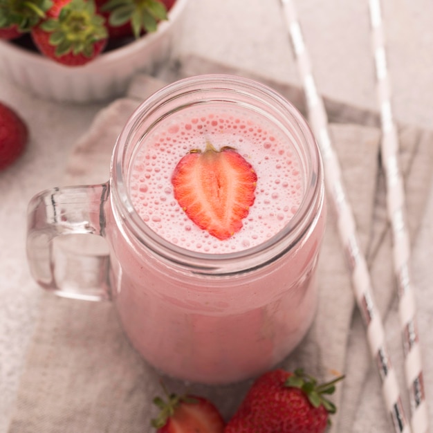 Foto gratuita alto ángulo de batido con fresas y pajitas