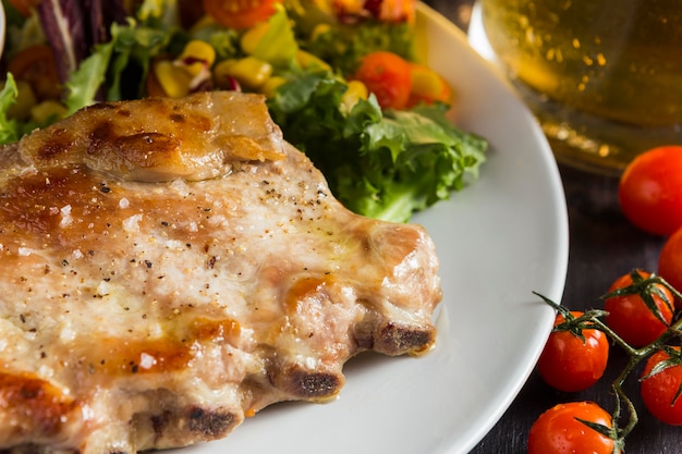 Alto ángulo de bistec en un plato con cerveza