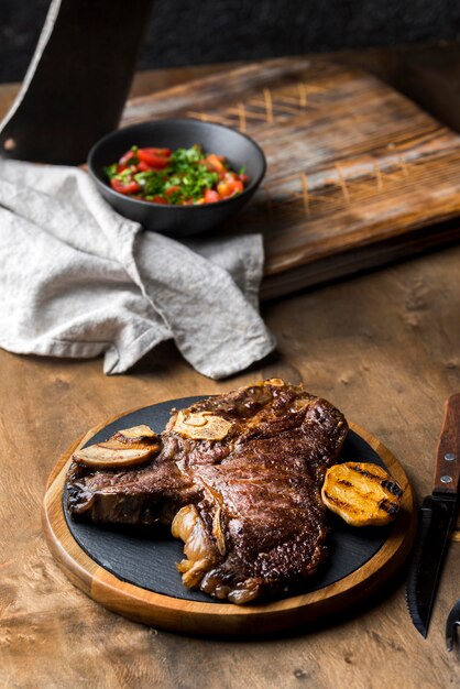 Alto ángulo de bistec en plato con cubiertos