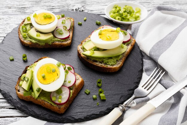 Alto ángulo de bocadillos con huevo y aguacate