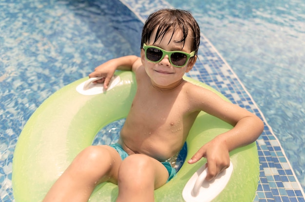 Alto ángulo boy en flotador en la piscina