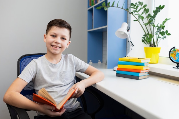 Foto gratuita alto ángulo boy en silla con libro