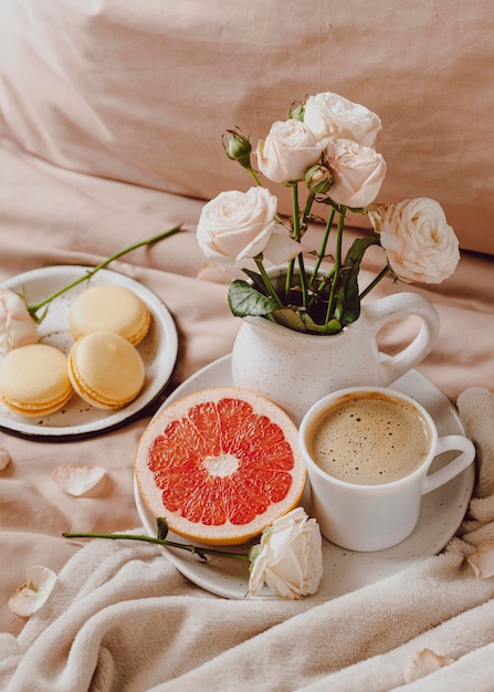 Alto ángulo de café de la mañana con pomelo y macarons