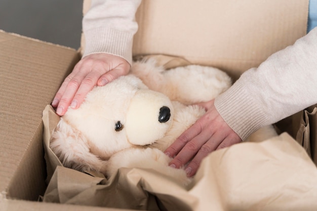 Alto ángulo de caja con osito de peluche preparado para ser enviado