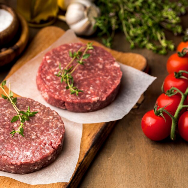 Alto ángulo de carne con tomates y hierbas.