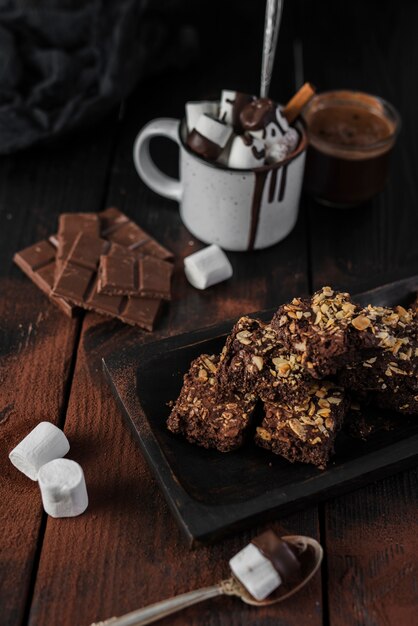 Alto ángulo de chocolate caliente y brownies con nueces