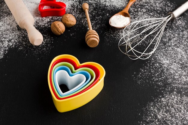 Alto ángulo de coloridas formas de corazón con utensilios de cocina